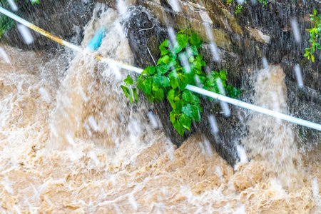 Tropical green city river canal and drainage in jungle nature full during a heavy monsoon rainfall in Patong Beach Kathu District Phuket Island Province Southern Thailand in Southeast Asia.の写真素材