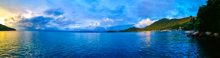 Amazing colorful golden sunset sunrise on the horizon panorama with dramatic clouds on the island...