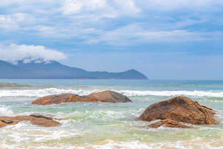 Aventureiro Beach tropical landscape panorama view with turquoise water waves palm trees boulders and rocks on Ilha Grande Big Island Angra dos Reis State of Rio de Janeiro Brazil.の写真素材
