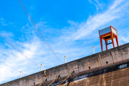 Brazil's largest dam in the world Itaipu for energy production on the border with Paraguay electricity pylons power poles building water river and blue sky in Foz do Iguacu State of Parana Brazil.の写真素材