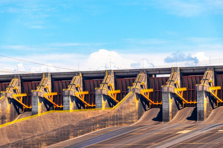 Brazil's largest dam in the world Itaipu for energy production on the border with Paraguay electricity pylons power poles building water river and blue sky in Foz do Iguacu State of Parana Brazil.の写真素材