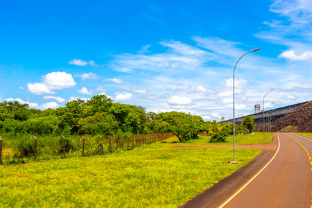 Brazil's largest dam in the world Itaipu for energy production on the border with Paraguay electricity pylons power poles building water river and blue sky in Foz do Iguacu State of Parana Brazil.の写真素材