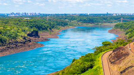 Brazil's largest dam in the world Itaipu for energy production on the border with Paraguay electricity pylons power poles building water river and blue sky in Foz do Iguacu State of Parana Brazil.の写真素材