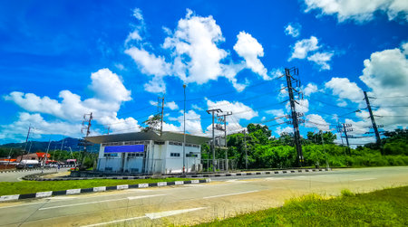 Colorful road street in tropical nature with cars traffic houses and buildings in Mai Khao on Phuket...