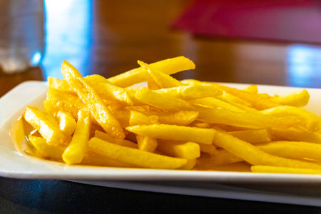Crispy French fries on a white plate.