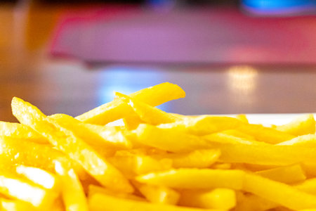 Crispy French fries on a white plate.