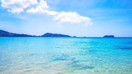 Amazing Patong Kamala Beach tropical landscape panorama view with blue sky turquoise sea water waves palm trees and clouds in Patong Beach Kathu Phuket Island Southern Thailand in Southeast Asia.の写真素材