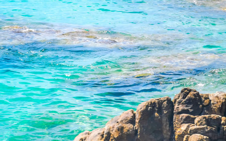Kalim Beach rocky tropical seascape shore coast with turquoise blue green clear water waves sand...
