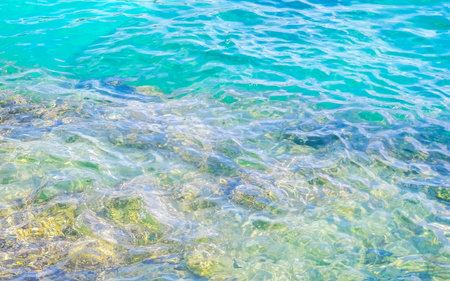 Kalim Beach rocky tropical seascape shore coast with turquoise blue green clear water waves sand...