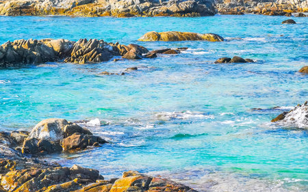 Kalim Beach rocky tropical seascape shore coast with turquoise blue green clear water waves sand...