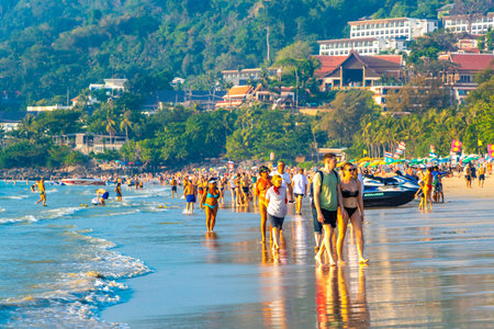 Kathu District Phuket Island Province Thailand 05. March 2026 Patong Kamala Beach bay with tourists people water waves sun loungers parasols tropical plants and palm trees in Phuket Thailand.のeditorial素材