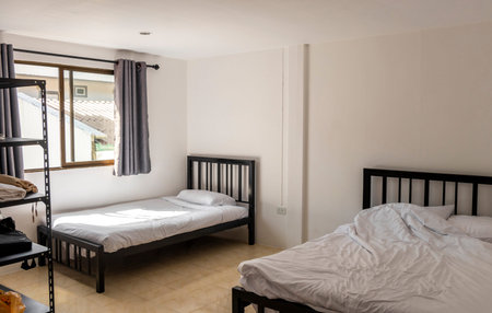 Kathu District Phuket Island Province Thailand 08. December 2025 Simple clean white cheap hotel apartment room with bed cupboard and shelves in Patong Beach Kathu Phuket Island Southern Thailand.のeditorial素材