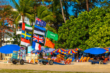 Kathu District Phuket Island Province Thailand 05. March 2026 Patong Kamala Beach bay with tourists people water waves sun loungers parasols tropical plants blue sky and palm trees in Phuket Thailand.のeditorial素材
