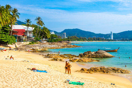 Kathu District Phuket Island Province Thailand 10. March 2026 Kalim Beach bay tropical landscape panorama view with tourists people turquoise water waves palm trees rocks in Patong Beach Thailand.のeditorial素材