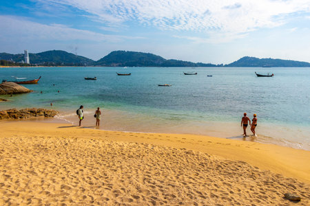 Kathu District Phuket Island Province Thailand 10. March 2026 Kalim Beach bay tropical landscape panorama view with tourists people turquoise water waves palm trees rocks in Patong Beach Thailand.のeditorial素材