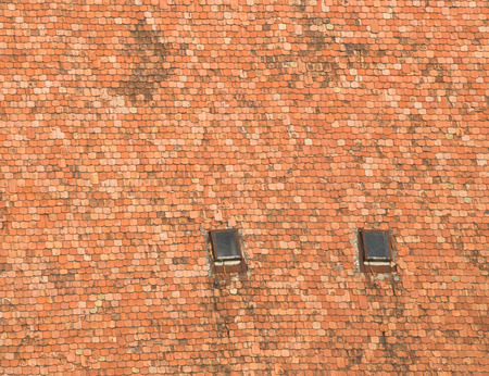 Old roof tiles background with two window, texture.の写真素材