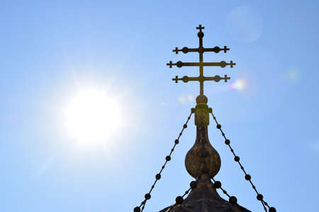 Romanian orthodox cross on sky and sun background in Cathedral of Curtea de Arges, Romanian Orthodox...