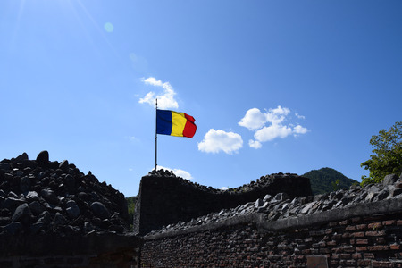 Romanian flag waving in the wind at the ruin of Poenari Castle. Romania National Flag.のeditorial素材