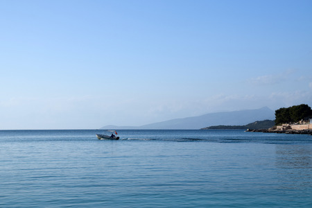 Small boat floats in the sea. Albanian riviera, Ksamil near Saranda. Albania.の写真素材