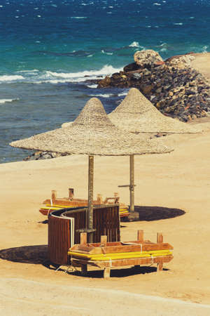 Deserted beach with wattled sun umbrellas on a seashore.の写真素材