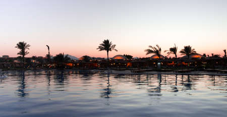 Reflection of trees and buildings  in the water in the evening after sunset.の写真素材