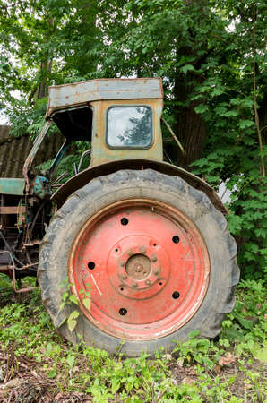 Old wheeled abandoned tractor. View on a big wheel.の写真素材