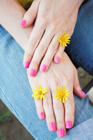 Women's hands with pink manicure and yellow flowers. Selective focusの写真素材
