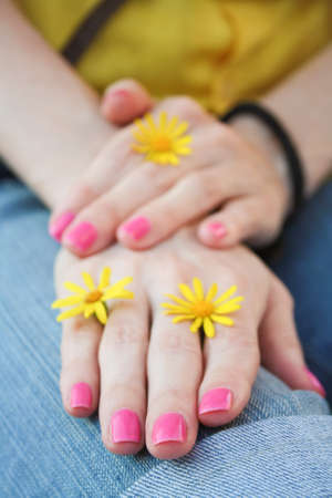 Women's hands with pink manicure and yellow flowers. Selective focusの写真素材