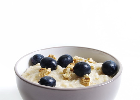 oats with nuts and grapes in bowl closeup isolatedの写真素材