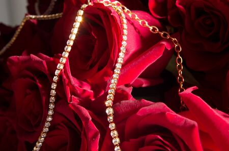 bouquet of red roses with gold jewelry closeupの写真素材