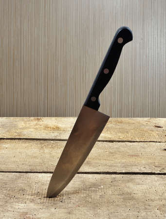 knife stucked in wooden tableの写真素材