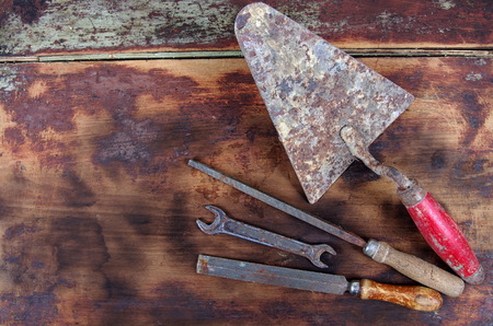 Rusty vintage tools on wooden background top view