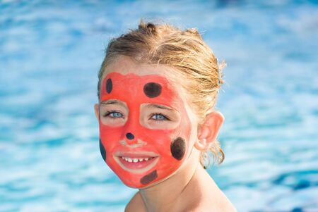 Girl with painted face by ladybugの写真素材