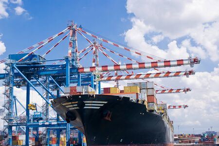 Cranes load a merchant ship in a commercial port terminal, Naples in Italy