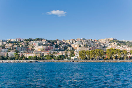 View from the sea of waterfront and buildings on the hills of Naples, Italyの写真素材