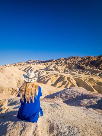 Sexy curvy woman admires the Landscape from the top of Zabriskie Point in Death Valley National Park in California. It is one of the hottest places in the world.の写真素材