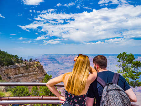 Arizona, USA - Aug 2019: Couple admires panorama of Grand Canyon National Park Mather Point, northwestern Arizona: View of Steep-sided canyon carved by Colorado River in Arizona UNESCO WHS in 1979のeditorial素材