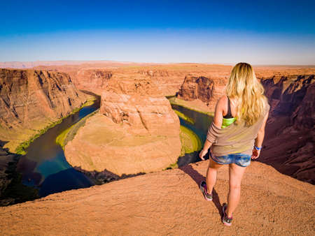 Sexy girl admires panorama of Horseshoe Bend, Page Arizona, the Colorado River and mass made of sandstone, has become major tourist destination.の写真素材