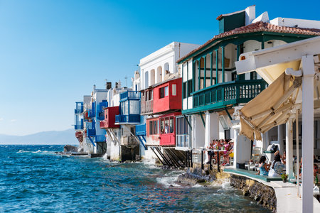 Mikonos, Greece - 11 Aug 2023: Alefkandra, The Little Venice, in the Old Town of Mykonos, Chora, with bright colors balconies and people waiting for happy hour at sunsetのeditorial素材