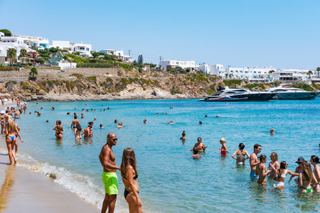Mykonos - 2023.08.18: Psarou beach in Greece, umbrella and luxury beach services. Psarou beach is the Mykonos favorite of international stars, paradise with spectacular landscape and all its comfortsのeditorial素材