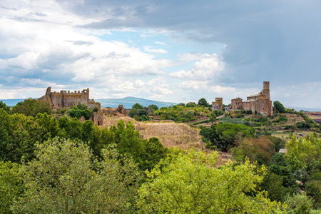 Lavello Tower and ruins of ancient castle are standing out in the skyline of Tuscania, a charming medieval town in the Lazio region of Italy, surrounded by lush vegetation and rolling hillsの写真素材