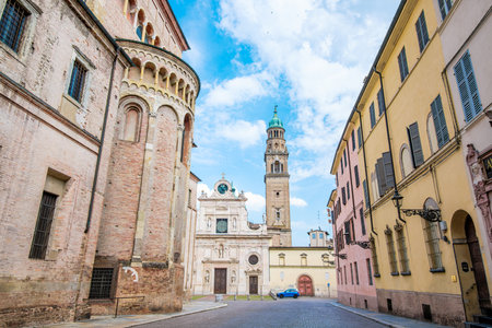 The Abbey of San Giovanni Evangelista stands tall at the end of Via Madre Anna Maria Adorni in Parma, Italy, showcasing its beautiful architecture and rich history amidst the charming cityscapeの写真素材