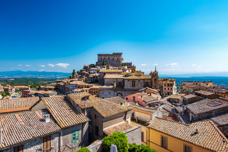 Overlooking the charming rooftops of Soriano nel Cimino in Latium, Italy, with its historic castle and vibrant buildings under a clear blue sky, showcasing the towns rich cultural heritageの写真素材