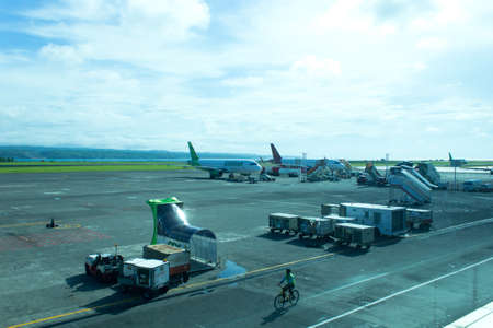 Bandar udara Ngurah Rai, Bali, Indonesia - December 4, 2018 : The plane that will take off at the airport. Many cargo cars will ship goods into the planeのeditorial素材