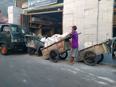 Tambora, West Jakarta, Indonesia - October 1, 2020 : Construction worker lifting sandbags