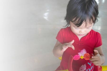 Cute Asian girl wearing a red shirt playing toys .の写真素材