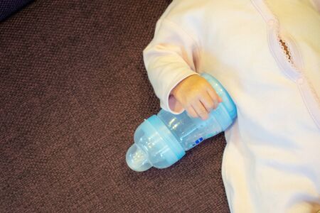 Newborn baby smile with milk power bottle, baby, boy, mom, mother conceptの写真素材