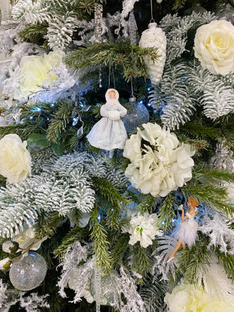 White Christmas tree decorations: a girl in winter clothes. Close-up
