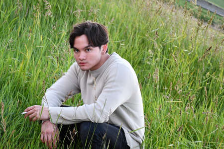 Handsome Man Sitting on a fieldの写真素材