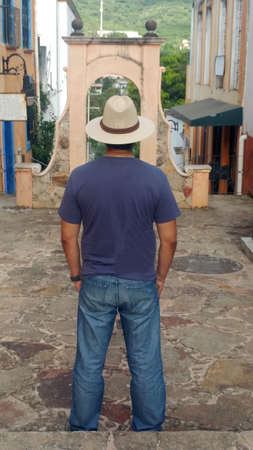 Latino adult man with hat as a tourist knowing the colonial style center of the magical town Jalpan de Serra in the Sierra de Queretaro Mexicoの写真素材